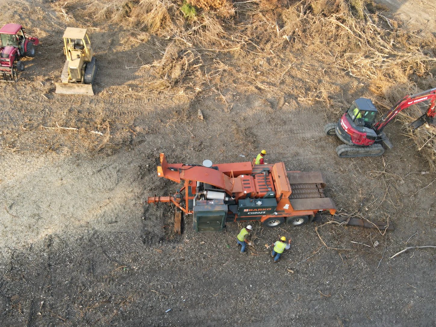 Overhead view of a whole-tree chipper, woody material and excavator