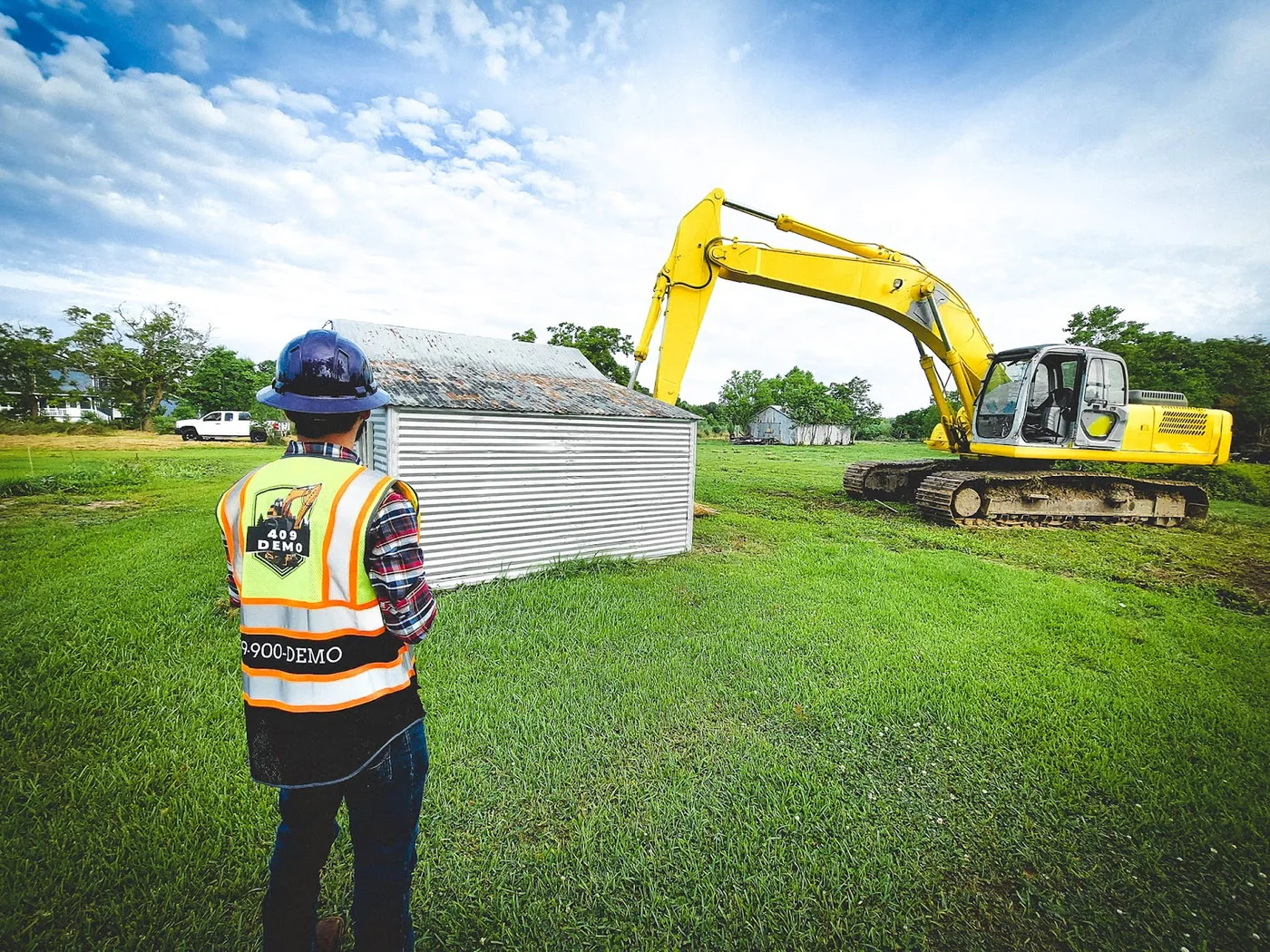 409 Demo crew member in a safety vest beside equipment