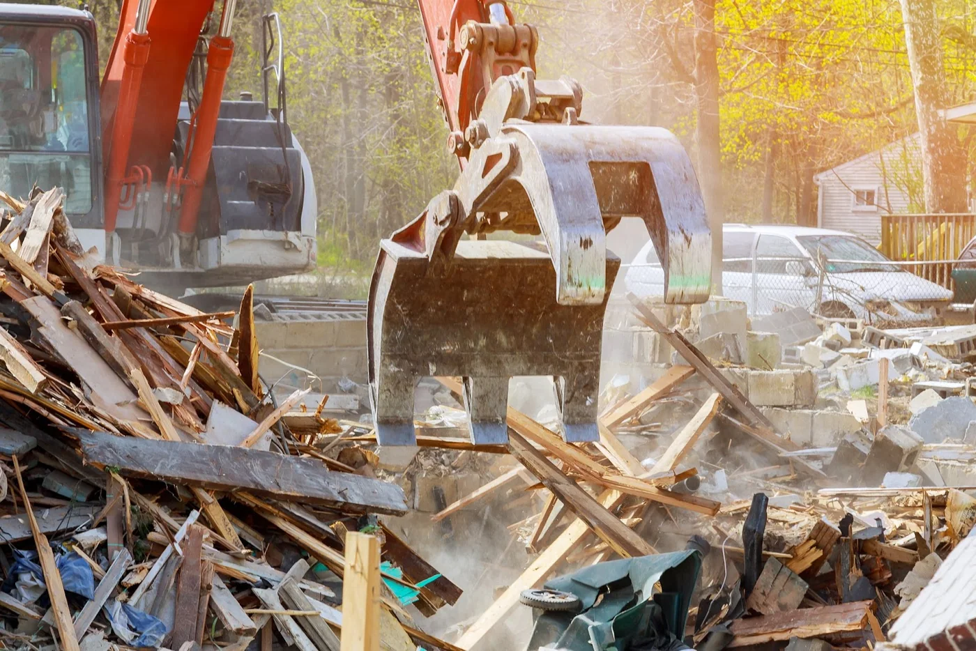 Excavator bucket and thumb handling timber and masonry demolition debris